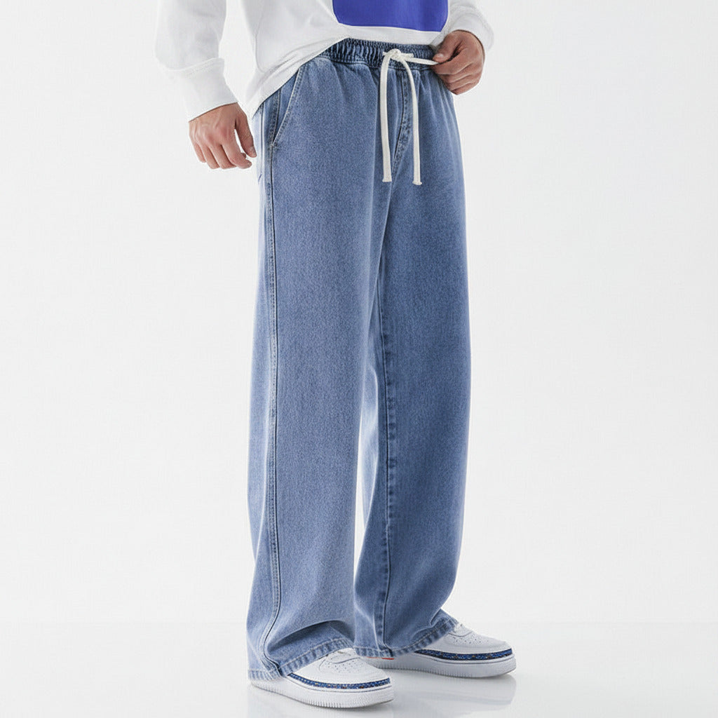 Person wearing light blue jeans and a white shirt on a white background