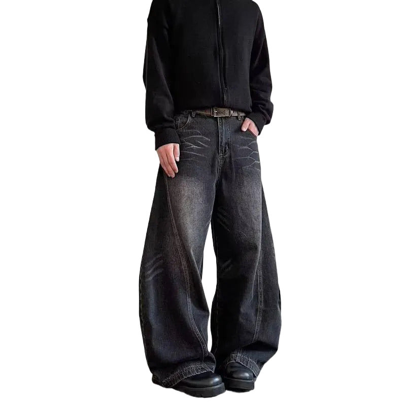 Person wearing wide-leg jeans and a black jacket on a white background