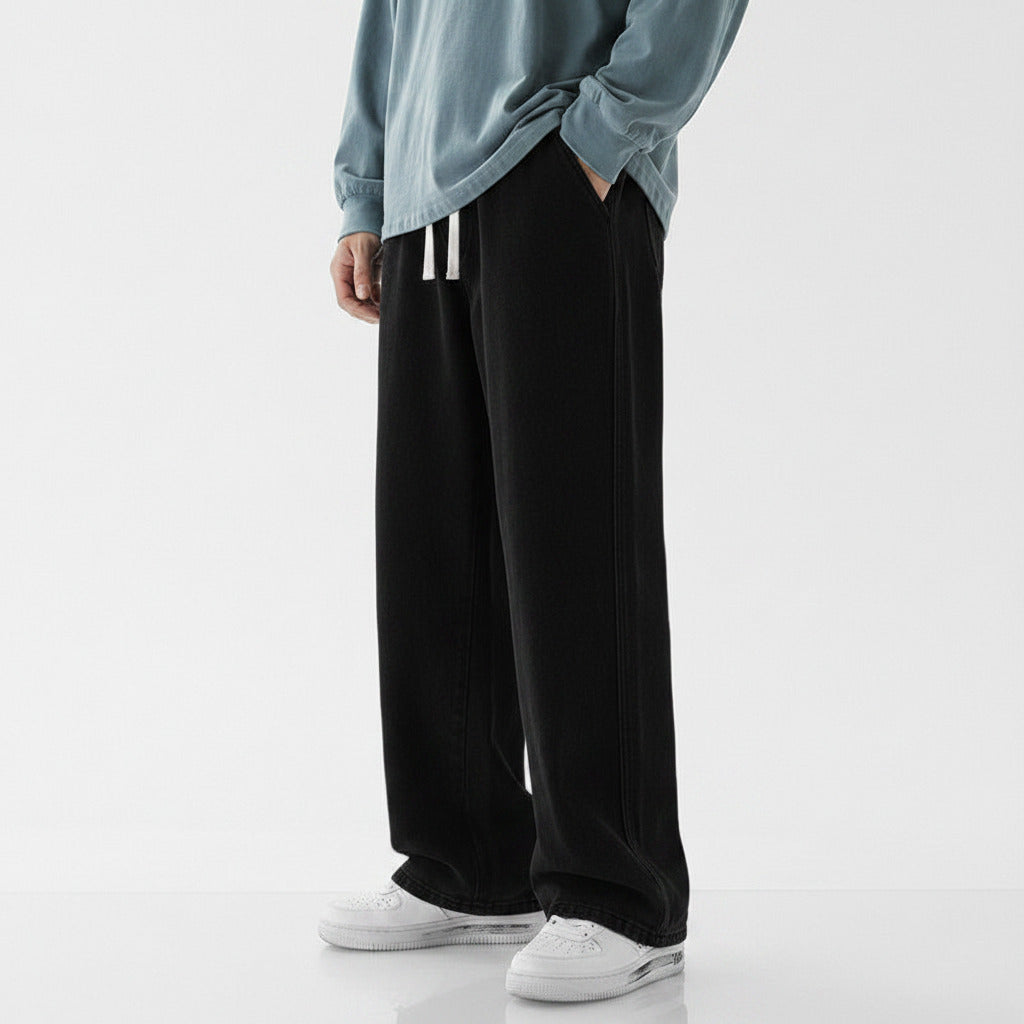 Person wearing black wide-leg pants and a light blue top on a white background