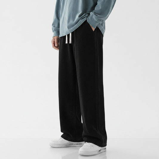 Person wearing black wide-leg pants and a light blue top on a white background