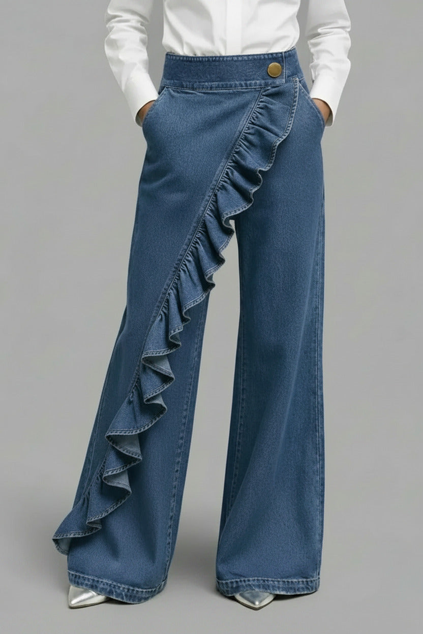 Blue denim pants with ruffled details on a gray background